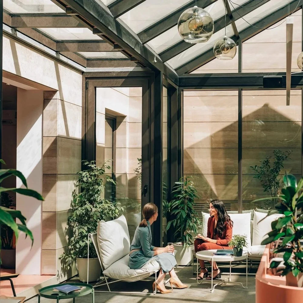Two people in conversation in a calm, light-filled setting